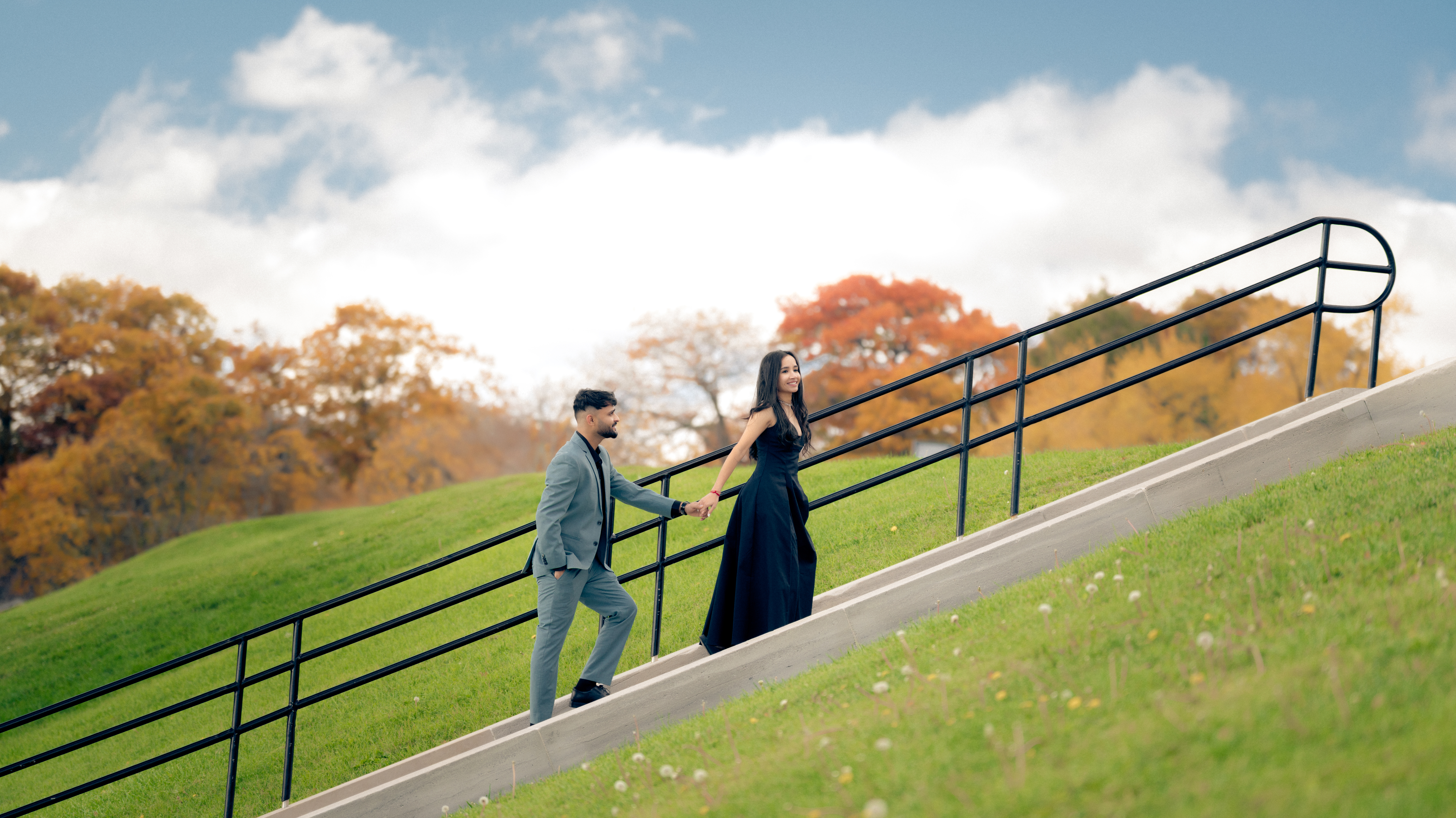 Engaged couple walking on steps in fall