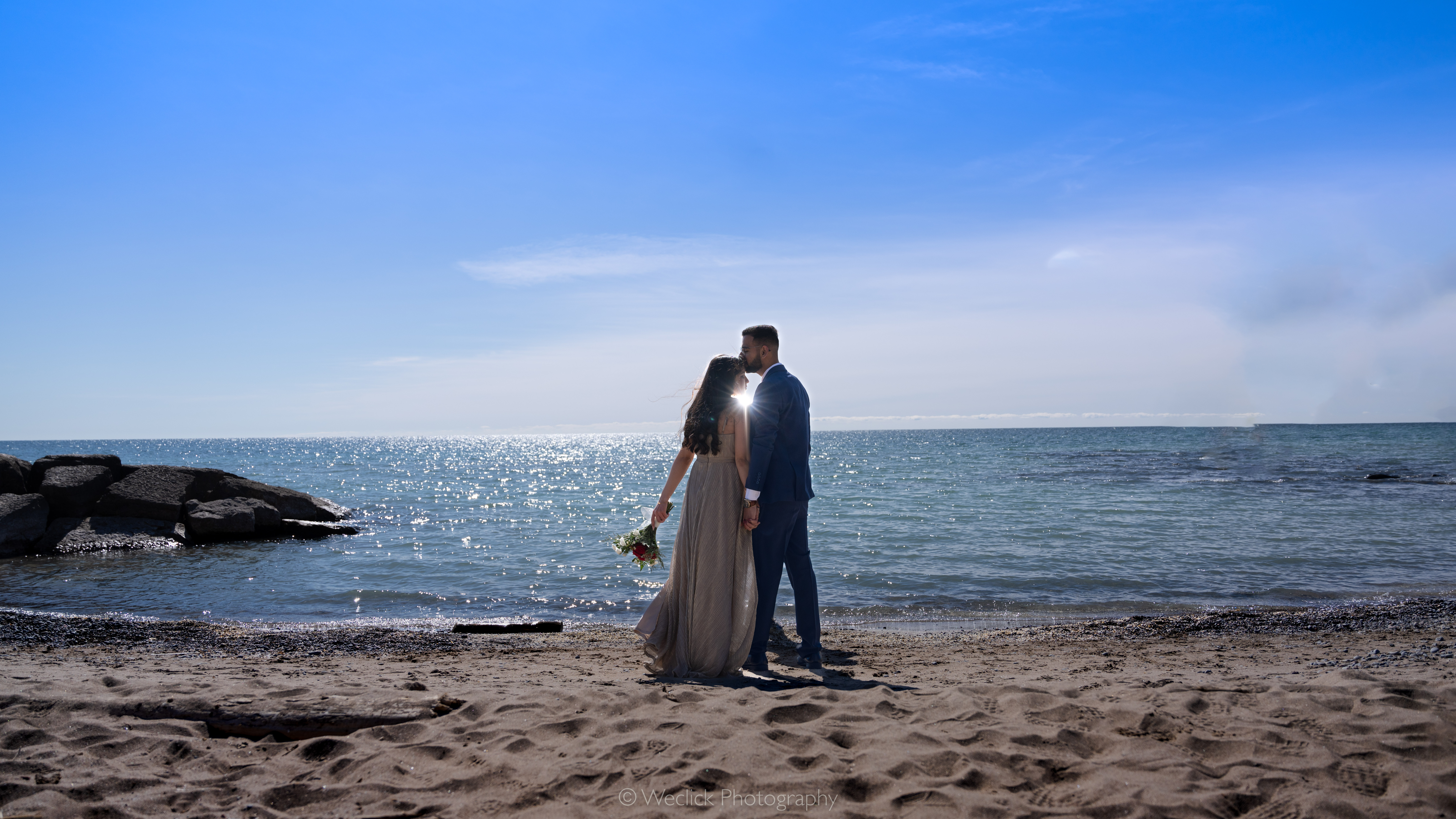Engagement couple seated together overlooking the water