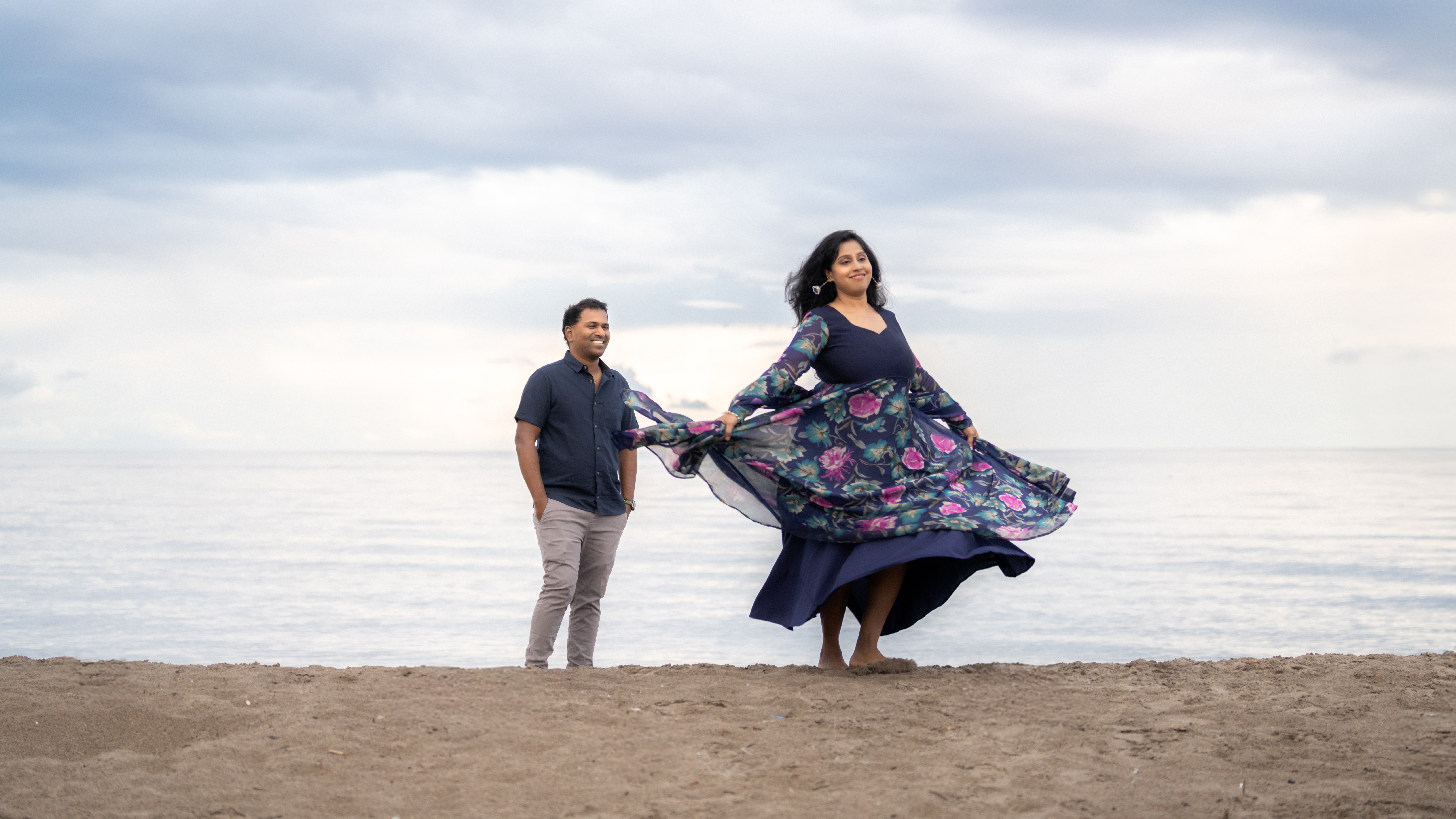 Couple photographed on a beach with flowing dress