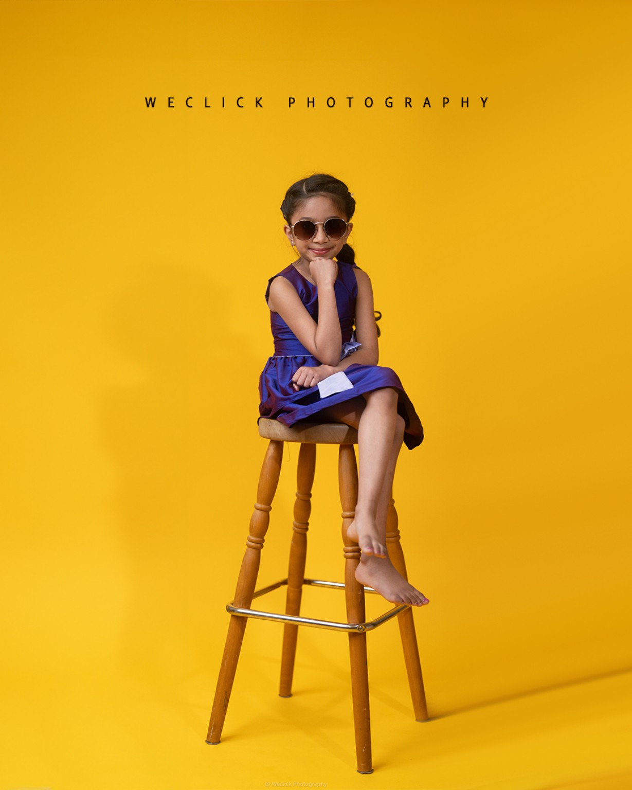 Child studio portrait on yellow background